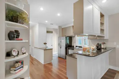 a kitchen with white cabinets and stainless steel appliances at Magnolia Cottage in Inlet Beach