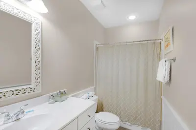 a bathroom with a sink and a toilet and a shower at Magnolia Cottage in Inlet Beach