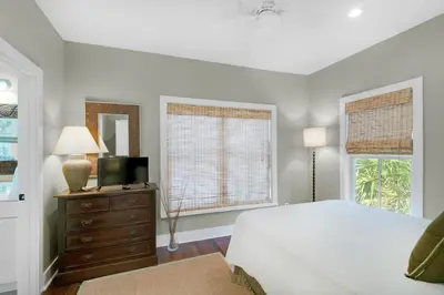 a bedroom with a bed and a television and a window at Magnolia Cottage in Inlet Beach