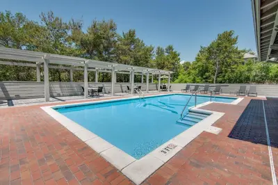 a swimming pool with chairs and a pavilion at Magnolia Cottage in Inlet Beach