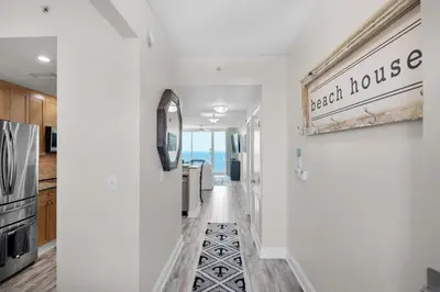 a hallway with a beach house sign on the wall at Aqua Resort 2103 in Panama City Beach