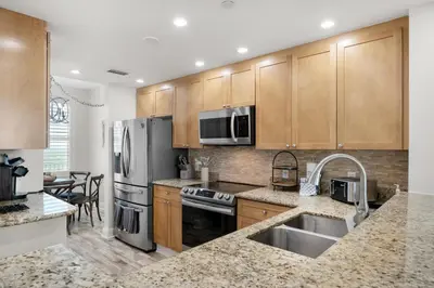 a kitchen with wooden cabinets and stainless steel appliances at Aqua Resort 2103 in Panama City Beach
