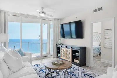 a living room with a white couch and a tv at Aqua Resort 2103 in Panama City Beach