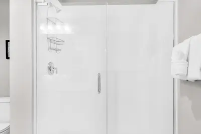 a bathroom with two shower doors and a toilet at Calypso 3-406 - Paradise by the Pier in Panama City Beach