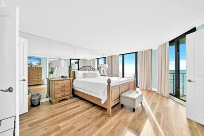 a bedroom with a bed and large windows at Edgewater Tower 2-404 in Panama City Beach