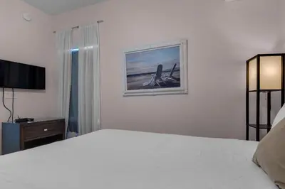 a bedroom with a white bed and a television at Tidewater 3013 in Panama City Beach