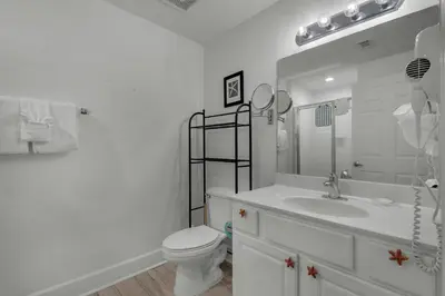 a white bathroom with a toilet and a sink at Tidewater 3013 in Panama City Beach
