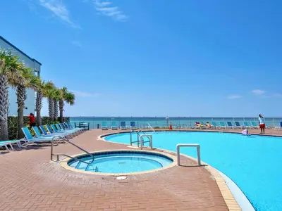 a large swimming pool with the ocean in the background at Tidewater 3013 in Panama City Beach