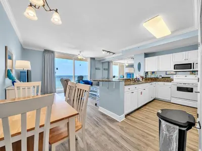 a kitchen and dining room with a table and chairs at Tidewater 607 in Panama City Beach