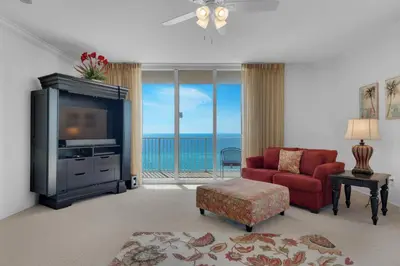 a living room with a red couch and a television at Tidewater 901 in Panama City Beach