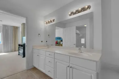 a white bathroom with a sink and a mirror at Tidewater 901 in Panama City Beach