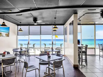 a restaurant with tables and chairs and a view of the ocean at Tidewater 901 in Panama City Beach