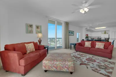 a living room with two red couches and a table at Tidewater 901 in Panama City Beach
