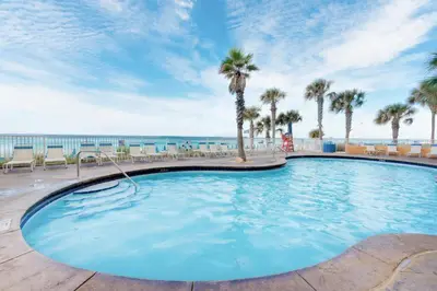 a large swimming pool with palm trees and the ocean at Splash 603E in Panama City Beach