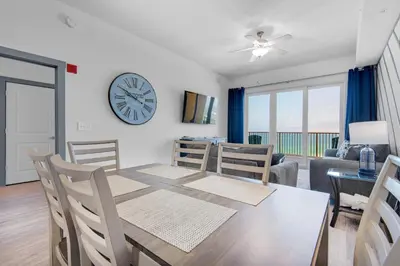 a dining room with a table and a clock on the wall at Calypso 3-2307 in Panama City Beach