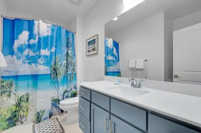 a bathroom with a sink and a toilet and a shower curtain at Calypso 3-2307 in Panama City Beach