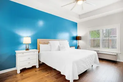 a blue bedroom with a white bed and a blue wall at Pearl Flamingo in Panama City Beach