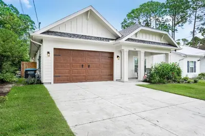 a white house with a brown garage at Pearl Flamingo in Panama City Beach