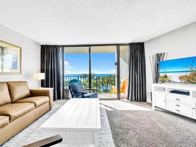 a living room with a couch and a tv at Edgewater Tower 1-305 in Panama City Beach
