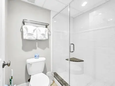 a bathroom with a toilet and a glass shower at Edgewater Tower 1-305 in Panama City Beach