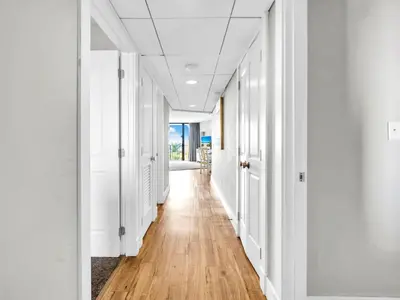 a hallway with white walls and a hard wood floor at Edgewater Tower 1-305 in Panama City Beach
