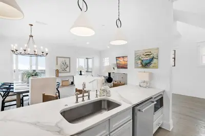 a white kitchen with a sink and a dining room at Churchill Dunes in Inlet Beach