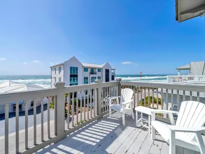 a balcony with white chairs and the beach at Churchill Dunes in Inlet Beach