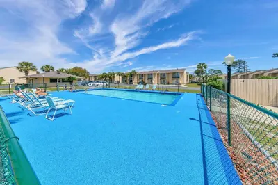 a swimming pool with chairs and a fence at Gulf Highlands 116H in Panama City Beach