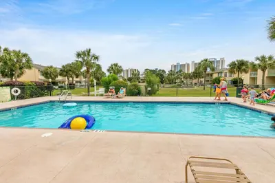 a swimming pool at a resort with people walking around it at Gulf Highlands 116H in Panama City Beach