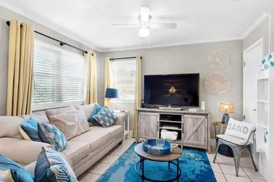 a living room with a couch and a tv at Gulf Highlands 116H in Panama City Beach