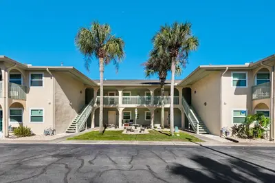 a large apartment building with palm trees at Gulf Highlands 116H in Panama City Beach