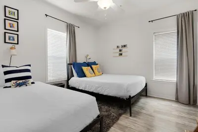 two beds in a room with white walls and windows at Heron's Watch Way 4104- Coach's Sand Dollar in Santa Rosa Beach