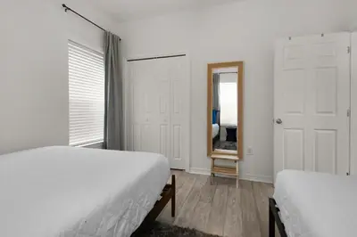 a white bedroom with two beds and a mirror at Heron's Watch Way 4104- Coach's Sand Dollar in Santa Rosa Beach