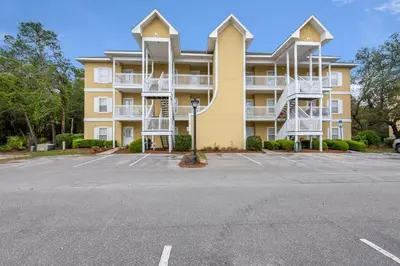 a large apartment building with a parking lot at Heron's Watch Way 4104- Coach's Sand Dollar in Santa Rosa Beach