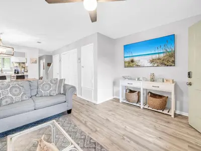 a living room with a couch and a tv at Portside R4 in Panama City Beach