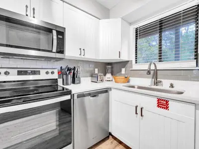 a white kitchen with a sink and a microwave at Portside R4 in Panama City Beach