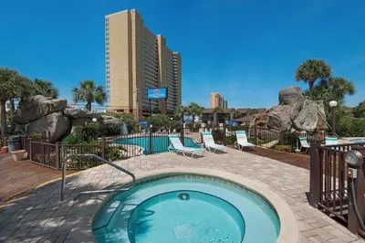 a swimming pool in a resort with a building at Portside R4 in Panama City Beach
