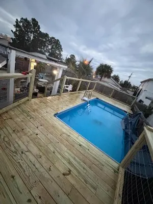 a wooden deck with a swimming pool on top of it at Peaceful Lydia Hide-O-Way - New Pool & Near Beach, Breakfast, Spa & Go-Karts! in Panama City Beach