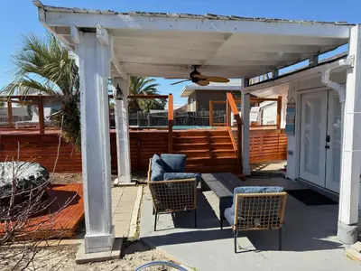 a pergola with two chairs and a table at Peaceful Lydia Hide-O-Way - New Pool & Near Beach, Breakfast, Spa & Go-Karts! in Panama City Beach