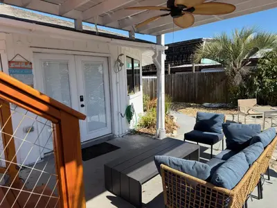 a patio with a couch and chairs and a ceiling fan at Peaceful Lydia Hide-O-Way - New Pool & Near Beach, Breakfast, Spa & Go-Karts! in Panama City Beach