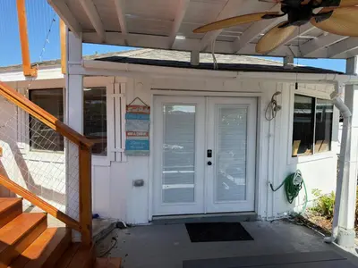 a front door of a house with a fan at Peaceful Lydia Hide-O-Way - New Pool & Near Beach, Breakfast, Spa & Go-Karts! in Panama City Beach