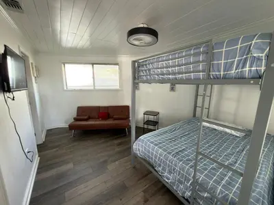 a bedroom with a bunk bed and a couch at Peaceful Lydia Hide-O-Way - New Pool & Near Beach, Breakfast, Spa & Go-Karts! in Panama City Beach
