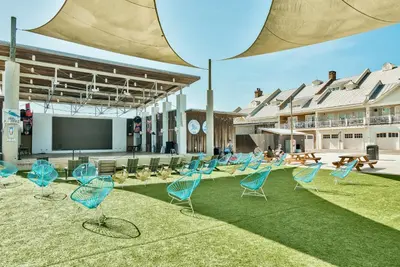 a group of chairs sitting on the grass in front of a building at Prominence on 30A by Panhandle Getaways in Watersound Beach