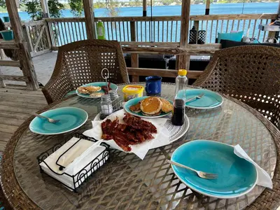a table with plates of food and pancakes on it at The Fifth Promise - A Cozy Lakehouse Retreat in Chipley