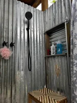 a shower head on a wooden fence with a shelf at The Fifth Promise - A Cozy Lakehouse Retreat in Chipley