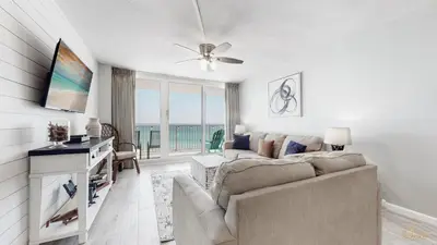 a living room with a couch and a ceiling fan at Beachfront - Renovated - Gulf view Bedroom - FLPCB5 in Panama City Beach