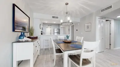 a dining room and kitchen with a table and chairs at Beachfront - Renovated - Gulf view Bedroom - FLPCB5 in Panama City Beach