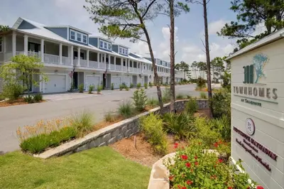 a view of a building with a sign and flowers at 30A Townhomes at Seagrove by Panhandle Getaways in Santa Rosa Beach