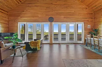 a living room with wooden walls and a wooden ceiling at Fun fishing river cabin 23mi to beach with private dock 3BD 2BA in Youngstown