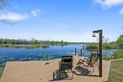a group of chairs sitting on a dock next to a lake at Fun fishing river cabin 23mi to beach with private dock 3BD 2BA in Youngstown